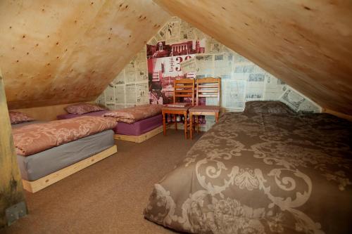 a attic bedroom with two beds and a table at Atomiņi in Aucugals