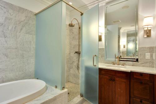 a bathroom with a shower and a tub and a sink at 6002 Maritime Villa in Kiawah Island