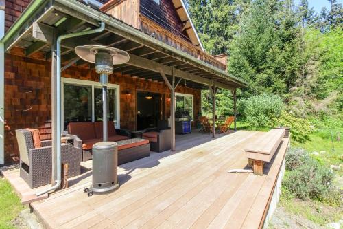 eine Holzterrasse mit Grill auf einem Haus in der Unterkunft Goss Lake Getaway in Langley