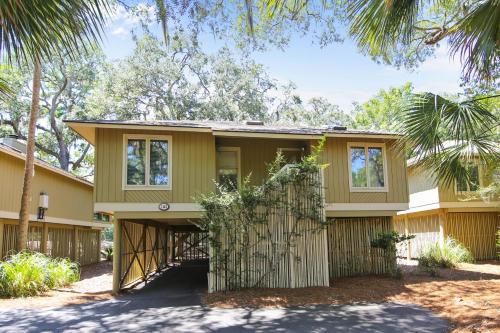 a yellow house with trees in front of it at Summerwind Cottage 1140 in Seabrook Island