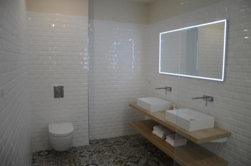 a bathroom with two sinks and a mirror and a toilet at Casa Mare E Vista in Propriano