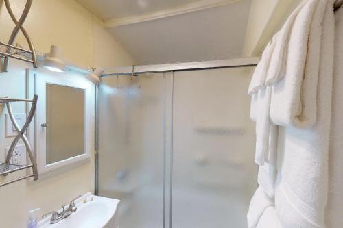 une salle de bain avec douche et lavabo dans l'établissement Loveland Cottage, à Girdwood