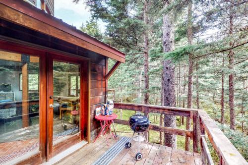 a porch of a cabin with a grill on a deck at Compton's in Girdwood