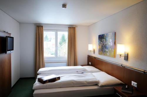 a hotel room with two beds and a window at Landgasthof Kreuz - Der Zwischenstopp mit Herz auf dem Weg in den Süden in Kappel bei Olten