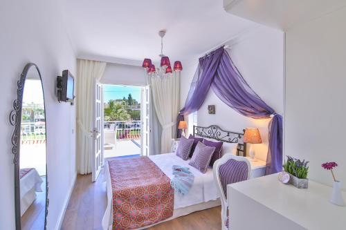a bedroom with a bed with a purple canopy at Alacati Sorf Hotel in Alacati