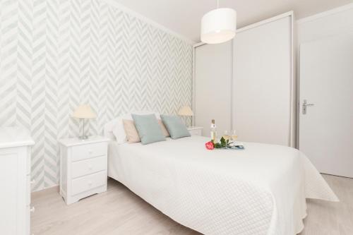 Dormitorio blanco con cama blanca y pared blanca en Ericeira T2 Navegantes Apartment, en Ericeira
