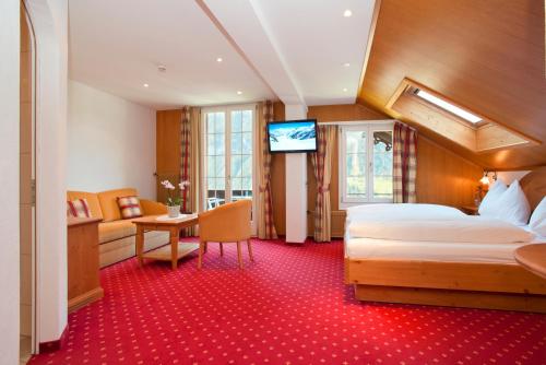 a hotel room with a bed and a television at Hotel Sonnenberg in Grindelwald