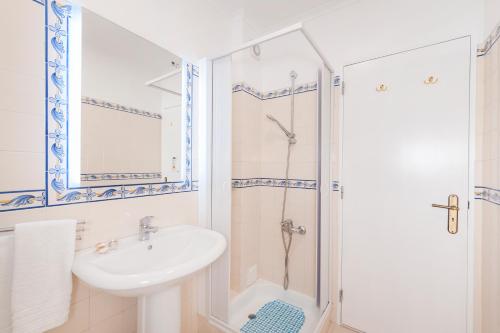 a white bathroom with a sink and a shower at Ericeira T1 Navegantes Apartment in Ericeira
