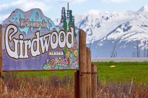 a welcome to dinosaur sign with mountains in the background at Brighton Condo #209 in Girdwood