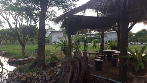 a garden with a table and trees and a building at Phurang Hill Resort in Kanchanaburi