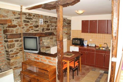 een keuken met een tafel en een tv aan de muur bij **ETNO Vila** - KRUSEVO in Kruševo