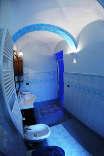 a blue bathroom with a sink and a toilet at B&B Miramare in Agerola
