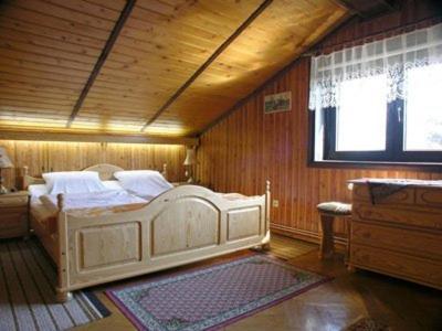 ウェバにあるAnker Kotwicaの木製の部屋に白いベッドが備わるベッドルーム1室