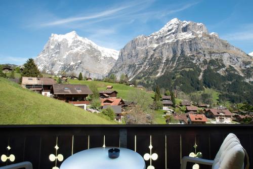 a person sitting on a balcony with a view of a mountain at Hotel Sonnenberg in Grindelwald