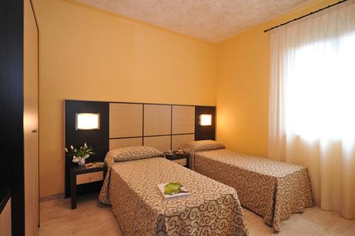 フマーネにあるAi Pigni De Cerùのベッド2台と窓が備わるホテルルームです。