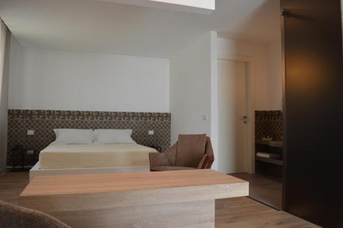 a hotel room with a bed and a chair at Masseria Torrepietra in Monopoli