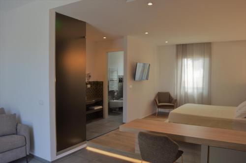 a bedroom with a bed and a desk and a couch at Masseria Torrepietra in Monopoli