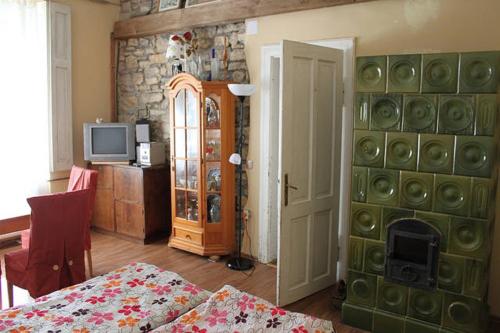 a living room with a fireplace and a room with a bed at Kőház apartman in Balatonfüred