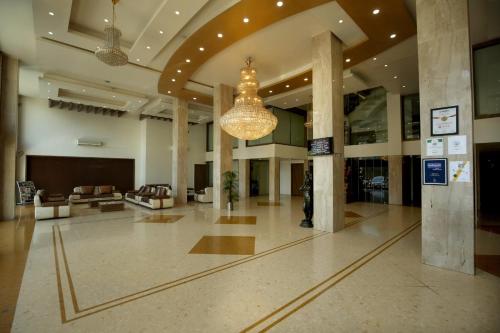 a large lobby with a chandelier in a building at Hotel The Evergrand Palace in Rajkot