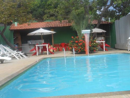 a swimming pool with a water fountain in front of a house at Pousada Renascer in Serra do Cipo