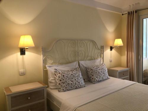 a bedroom with a bed with pillows and two lamps at Guest House Sea Breeze in Sveti Stefan
