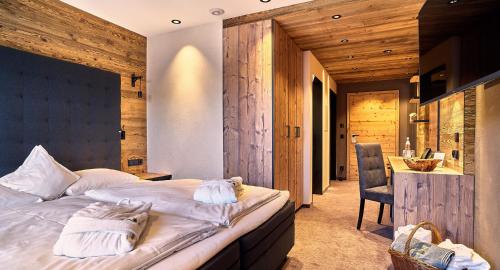 a bedroom with a bed and a desk and a chair at Zedernhof Gesundheits- & Wellnesshotel in Stamsried