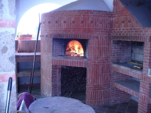 a brick oven with a fire in it at Casale Nido dell'Aquila in Squille
