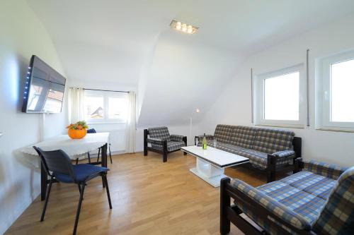 ein Wohnzimmer mit einem Sofa, einem Tisch und Stühlen in der Unterkunft Ferienwohnung Biermann in Aspach