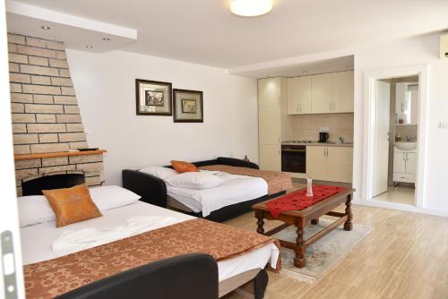 Sala de estar con 2 camas y mesa en Guest House Evropa, en Ulcinj