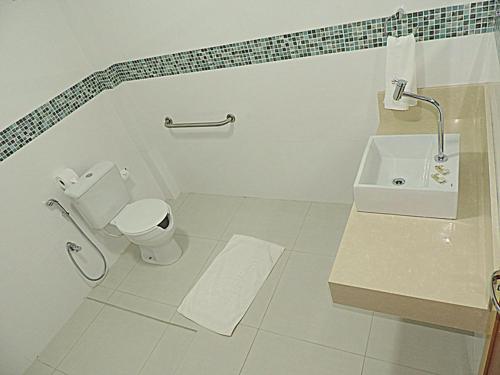 a white bathroom with a toilet and a sink at Hotel Pequeno Mundo 2 in Campo Verde
