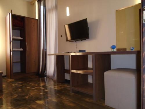 a room with a desk with a television on a wall at HOTEL Dadu in Batumi