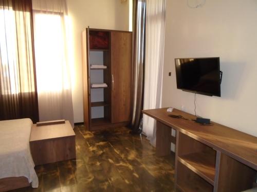 a room with a desk with a television on a wall at HOTEL Dadu in Batumi