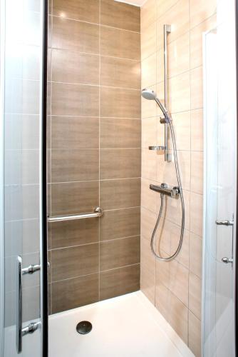 une salle de bain avec une douche avec une porte vitrée dans l'établissement Domitys Sophia, à Nîmes