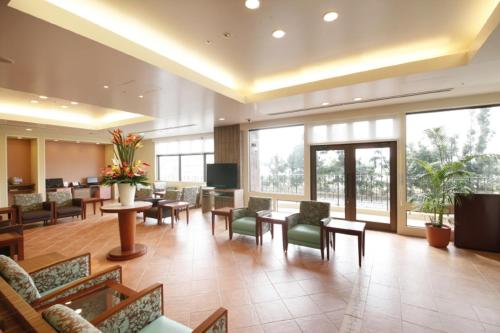 a lobby with a waiting room with tables and chairs at Vessel Hotel Campana Okinawa in Chatan