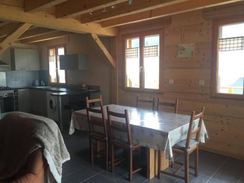 a kitchen and dining room with a table and chairs at Au cœur du bois in Le Bouilly