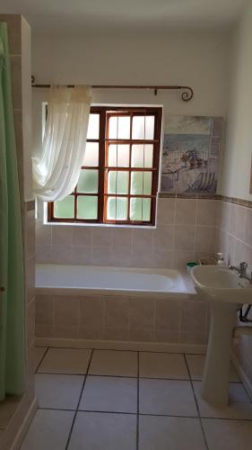 a bathroom with a tub and a sink and a window at Sea Valley Villa in Port Alfred