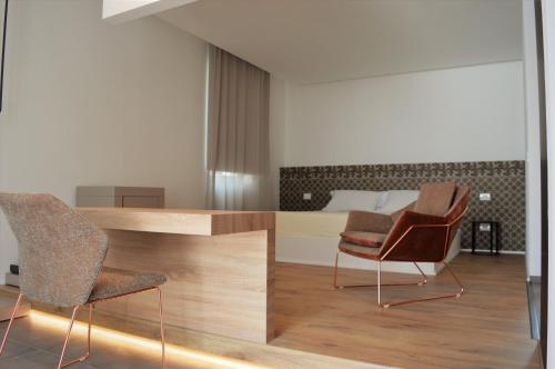a bedroom with a bed and two chairs and a desk at Masseria Torrepietra in Monopoli
