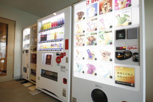 a vending machine with magnets and pictures on the wall at Vessel Hotel Campana Okinawa in Chatan