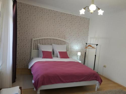 a bedroom with a large bed with pink sheets at Union Square Apartment 2 by NUX in Cluj-Napoca