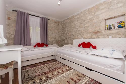 two beds in a room with stone walls at Villa Hurem in Trogir