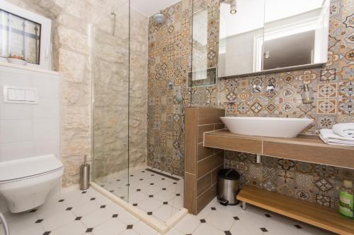 a bathroom with a shower and a toilet and a sink at Villa Hurem in Trogir