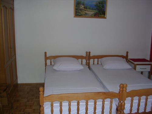 two twin beds in a room with a picture on the wall at Apartment Perkovic Jadranka in Kornić