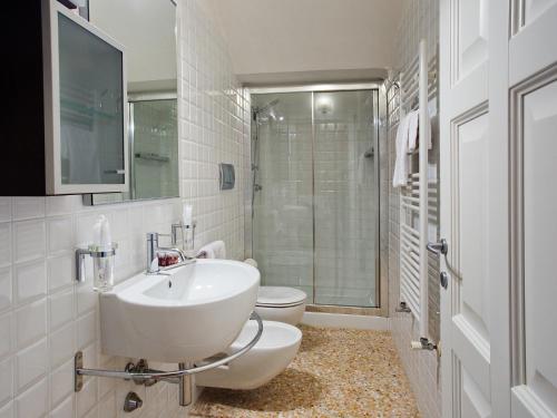 bagno bianco con lavandino e servizi igienici di Residence Le Bugne a Noale