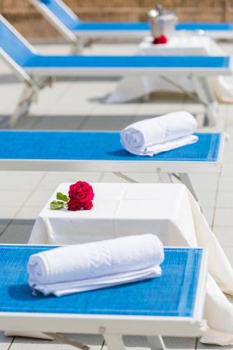 a table with towels and a red rose on it at Hotel Stefania in Cesenatico