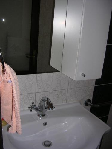 a bathroom with a white sink and a mirror at Apartment Perkovic Jadranka in Kornić