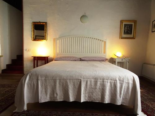 1 dormitorio con 1 cama grande con colcha blanca en Antico Borgo Camporeso, en Galbiate