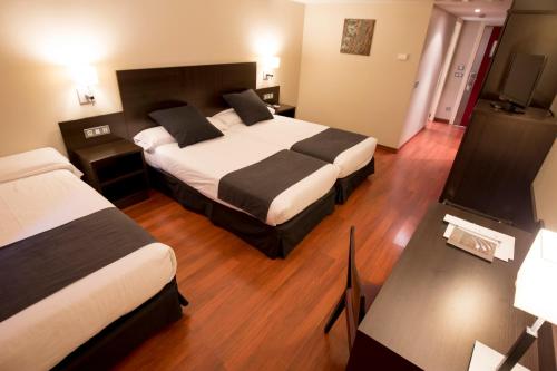 a hotel room with two beds and a television at Font D'Argent Canillo in Canillo