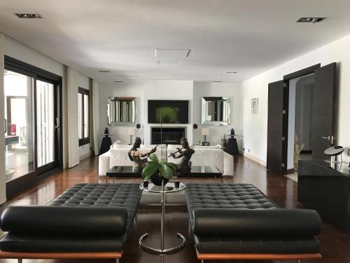 salon z czarnymi skórzanymi meblami i kanapą w obiekcie Villa Los Halcones Sotogrande Golf w mieście San Roque