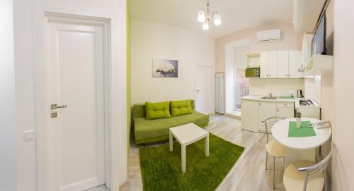 a living room with a green couch and a kitchen at Basseynaya Apart Hotel in Kyiv