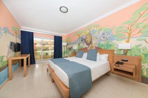 a bedroom with a bed with a painting on the wall at Ukino Palmeiras Village - 24h All Inclusive in Armação de Pêra
